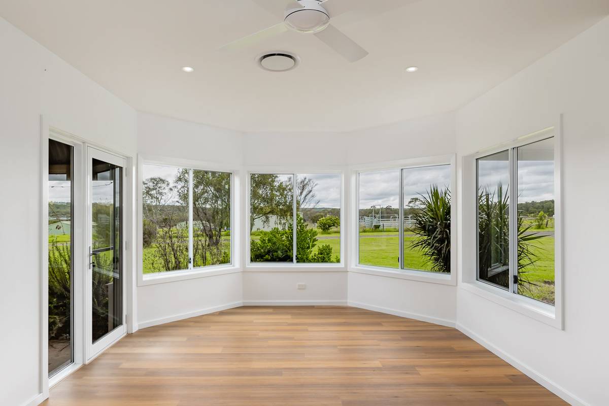 Wide open living space paired with modern sun room, sliding doors and windows leading to garden